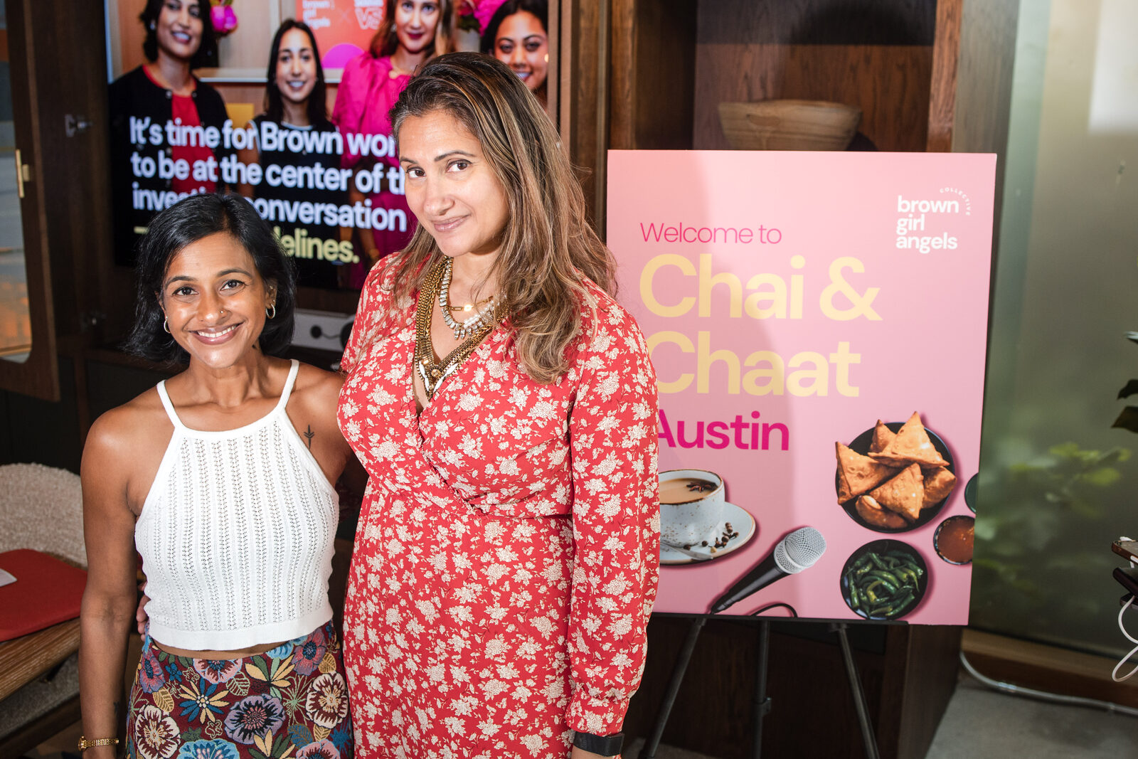 Bhargavi Varma with a Chai & Chaat Austin guest beside the &lsquo;join the chaat&rsquo; signage
