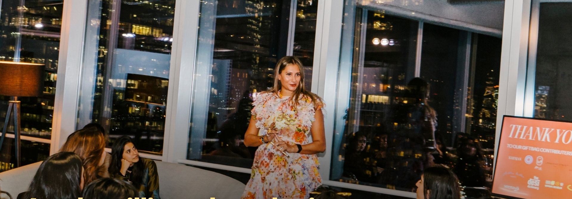 A woman at a Brown Girls Elevated Experiences gathering, skyline behind her