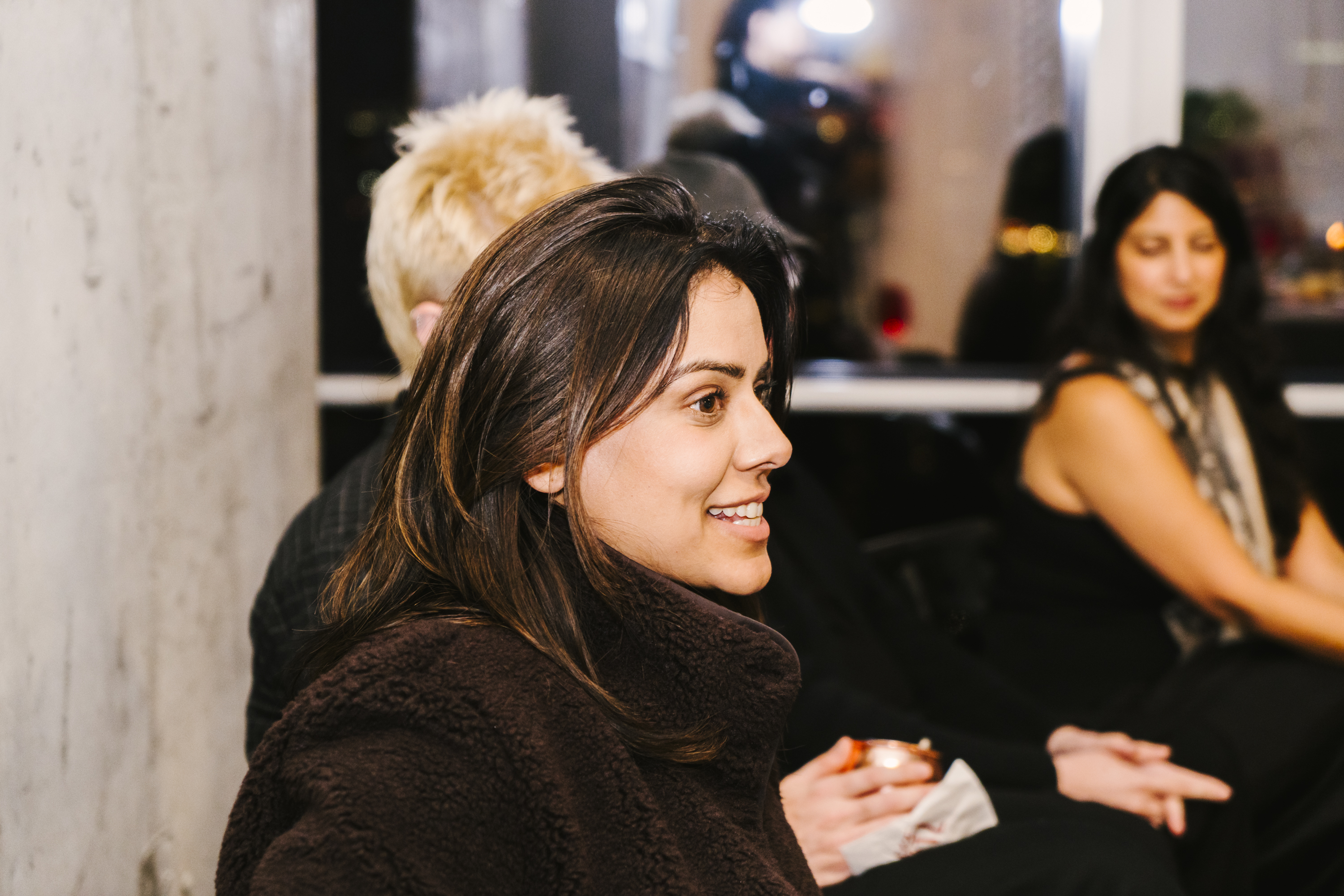 A senior South Asian woman mid-laugh at the SickKids fundraiser — the candid side of the didi room.
