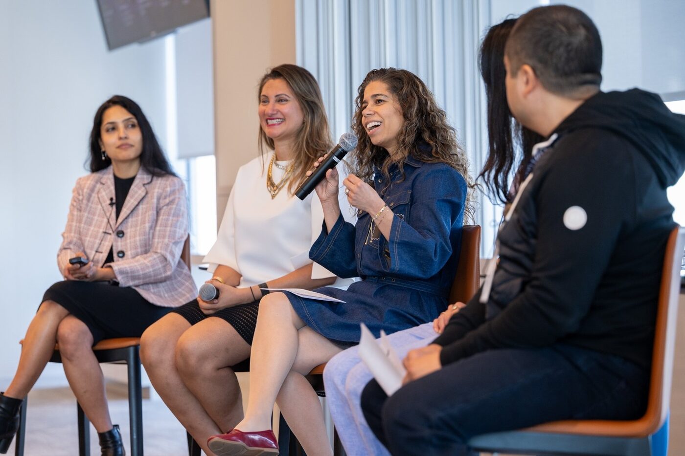 Brown Girl Angels Investing in Art panel — four women on stage, one laughing mid-mic, the room leaning in.